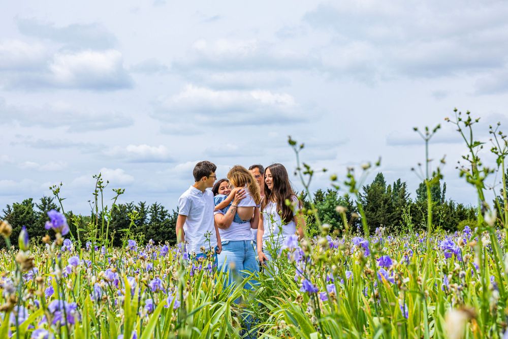 Famille dans un champ d’iris pendant une séance photo naturelle en Provence