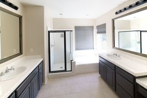 Spacious master bathroom with dual vanities, large mirrors, walk-in shower, soaking tub, and tile floors.