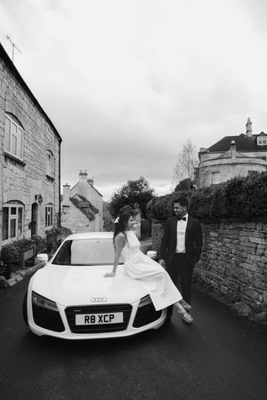 Couple walking during engagement photoshoot in the Cotswolds village of Painswick.