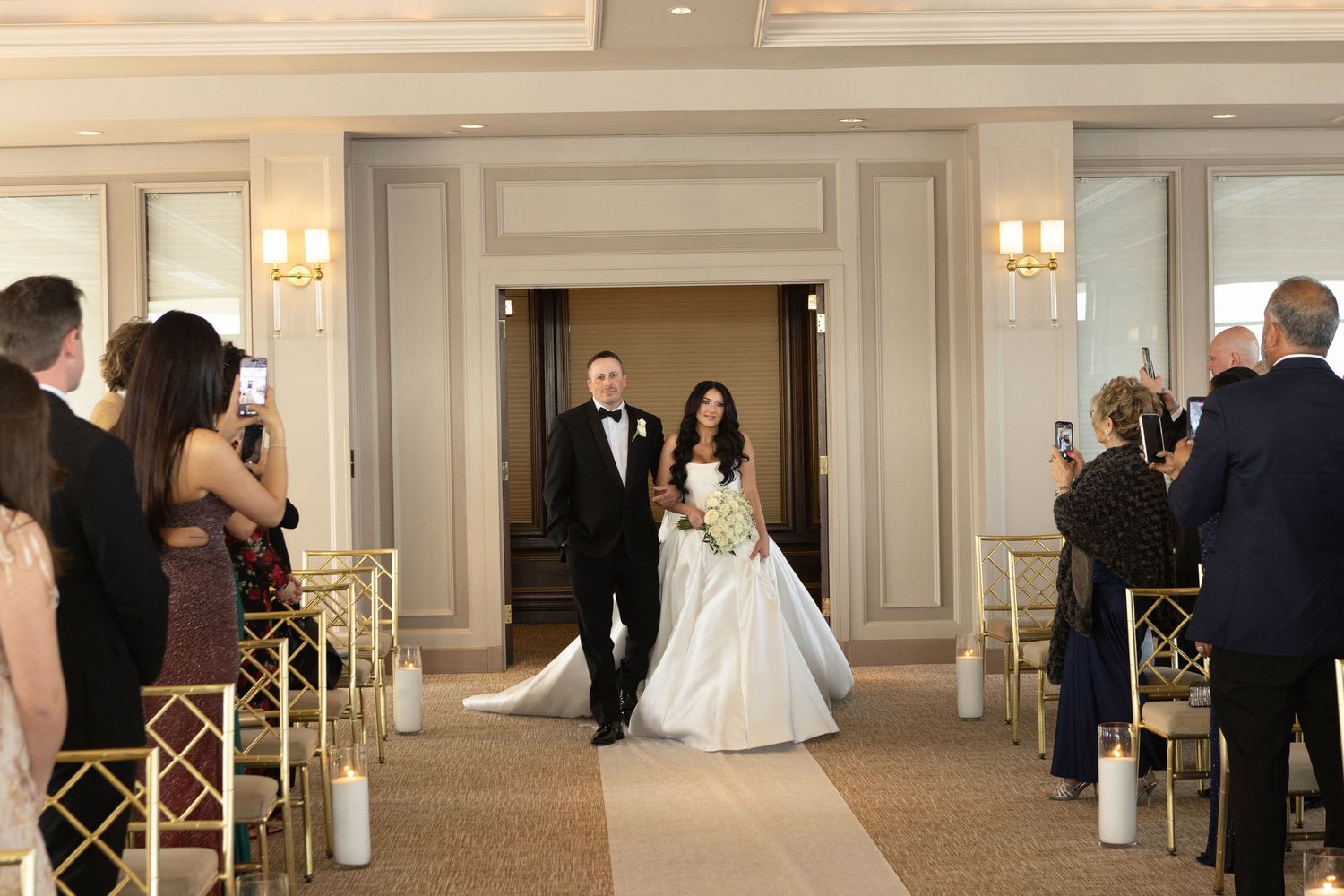 Bride walking down the aisle with her father during a luxury wedding ceremony overlooking the water in Westchester, New York.
