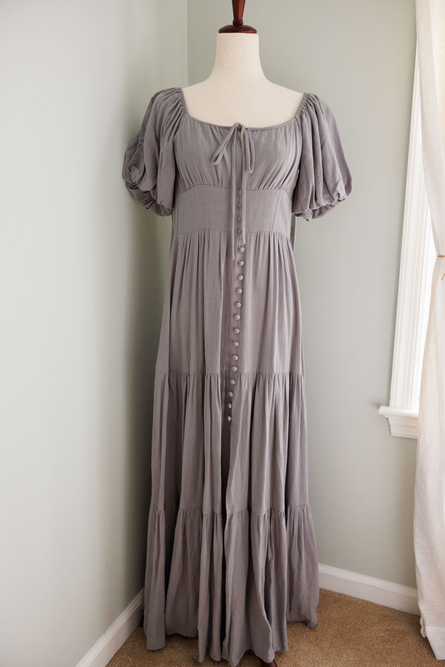 Vintage cream-colored peasant dress with puff sleeves and corset back lacing displayed on mannequin from multiple angles.