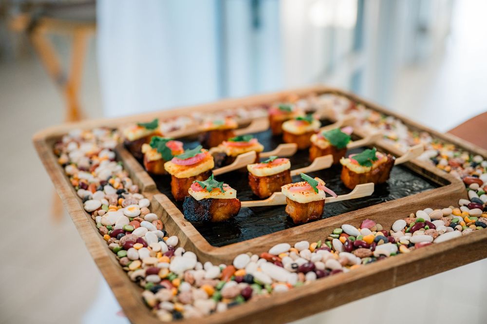 Elegant wooden platter of colorful sushi rolls and appetizers arranged on decorative stones.