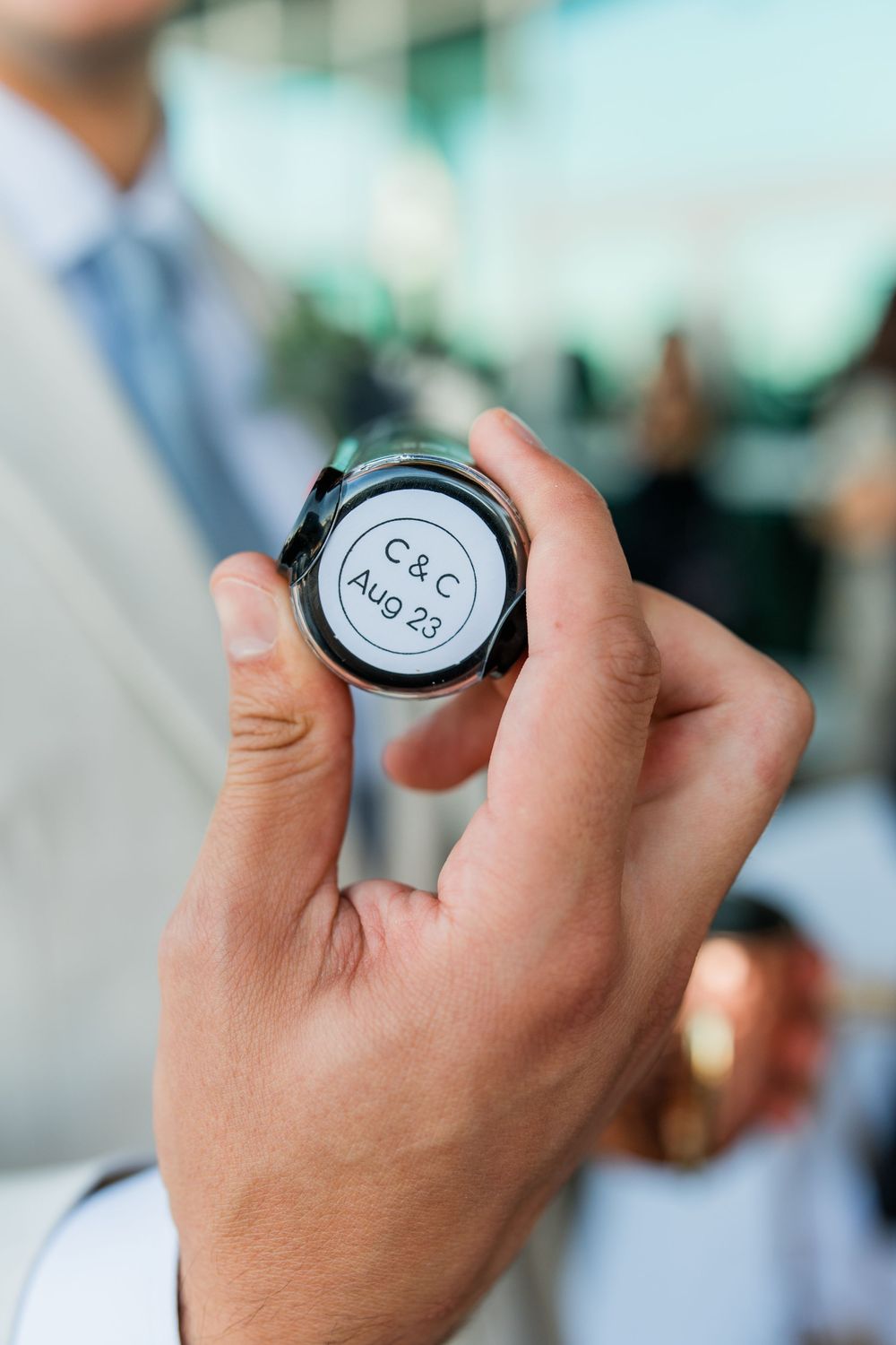 Close up of hand holding a small circular object with text.