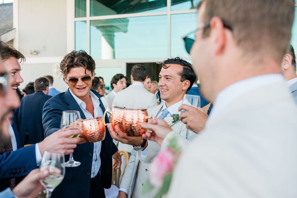 Wedding celebration with guests mingling and toasting during a cocktail reception.