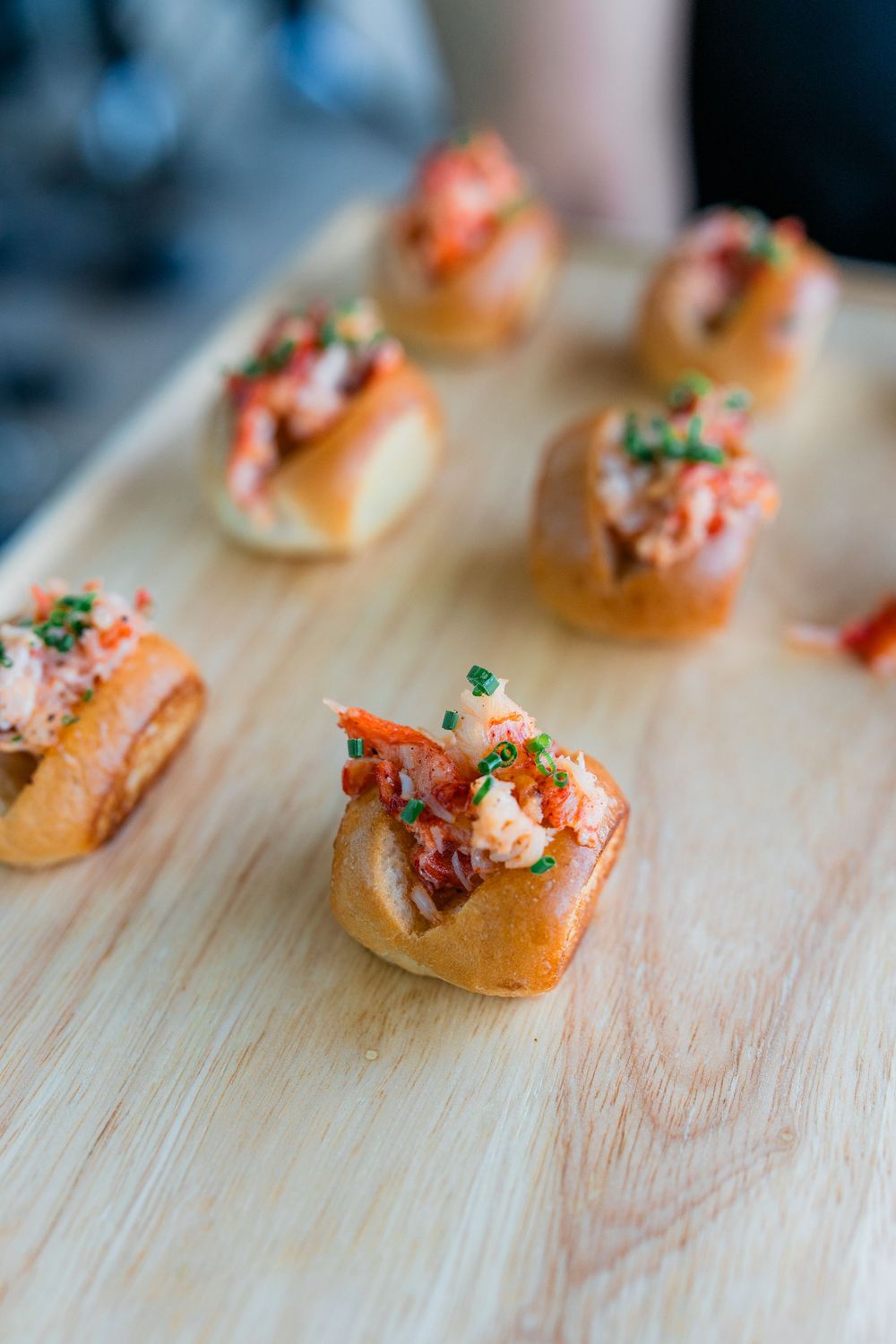 Appetizers with seafood and garnish arranged on a wooden serving board.