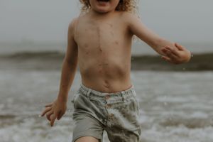 Playful moment captured at the beach in muted tones.