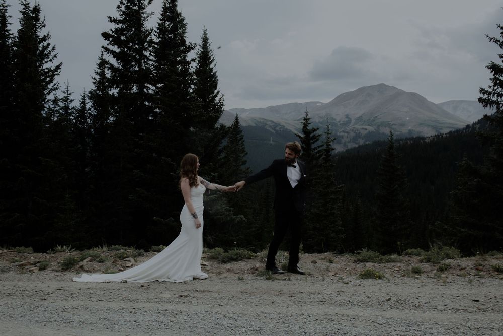 Mountain wedding ceremony site with evergreen trees and peaks in the distance.