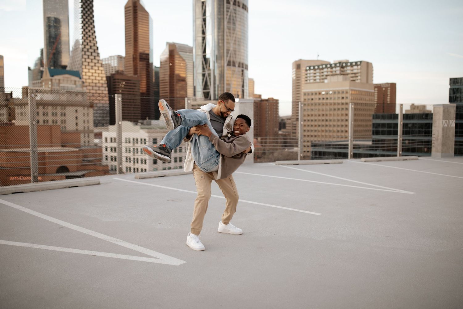 People walking and interacting on a spacious rooftop with modern cityscape views.