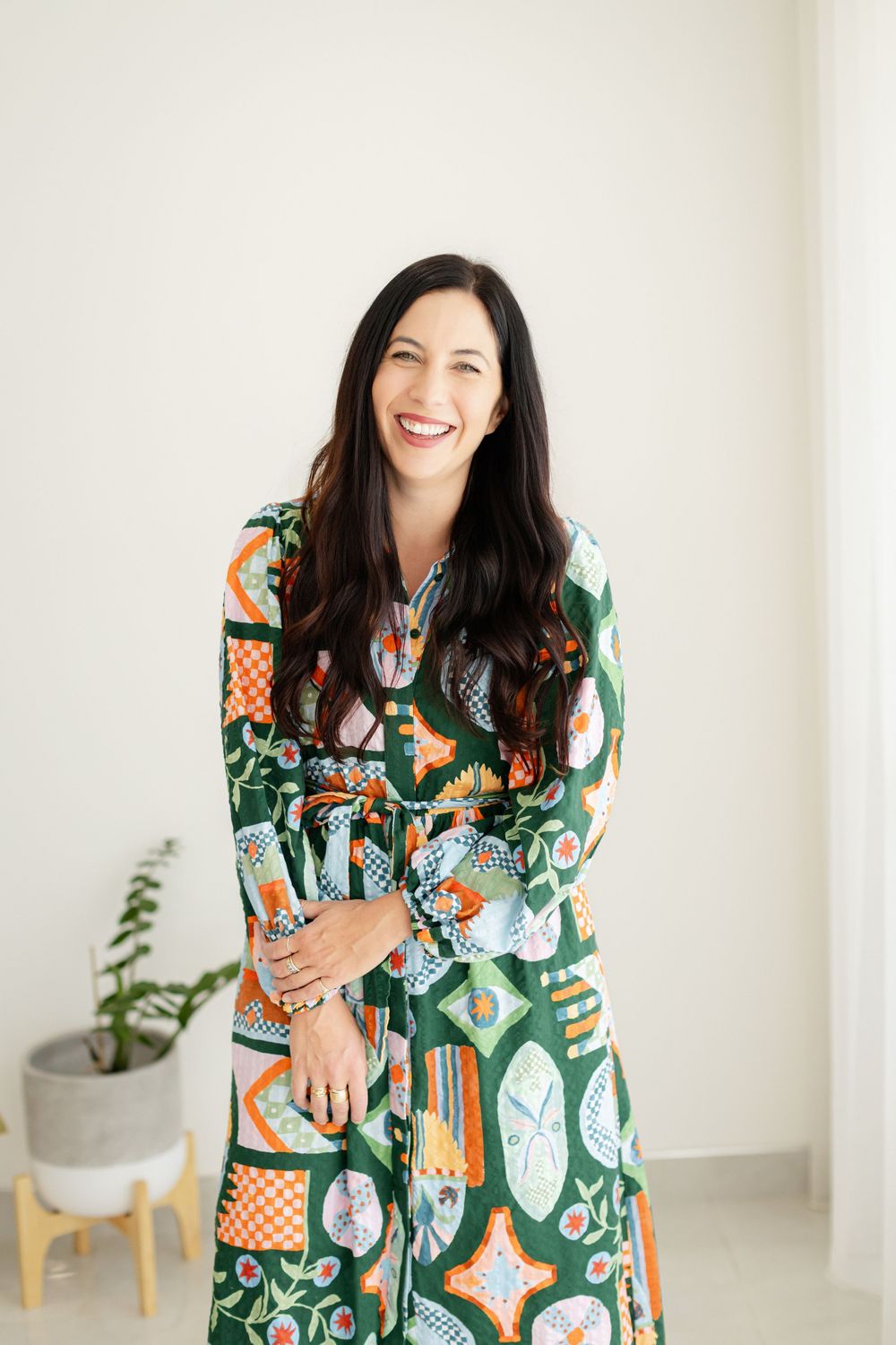 A person in a vibrant green and orange patterned dress smiles during a Branding Photography Session