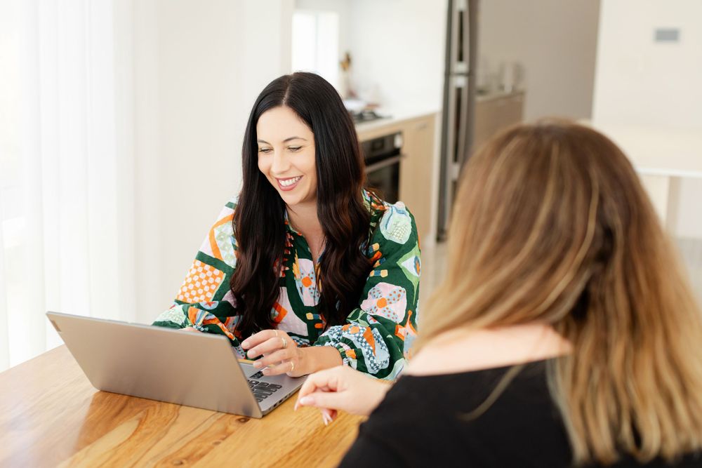 Two people sit at a table working together on a Creative Maison photo shoot location.