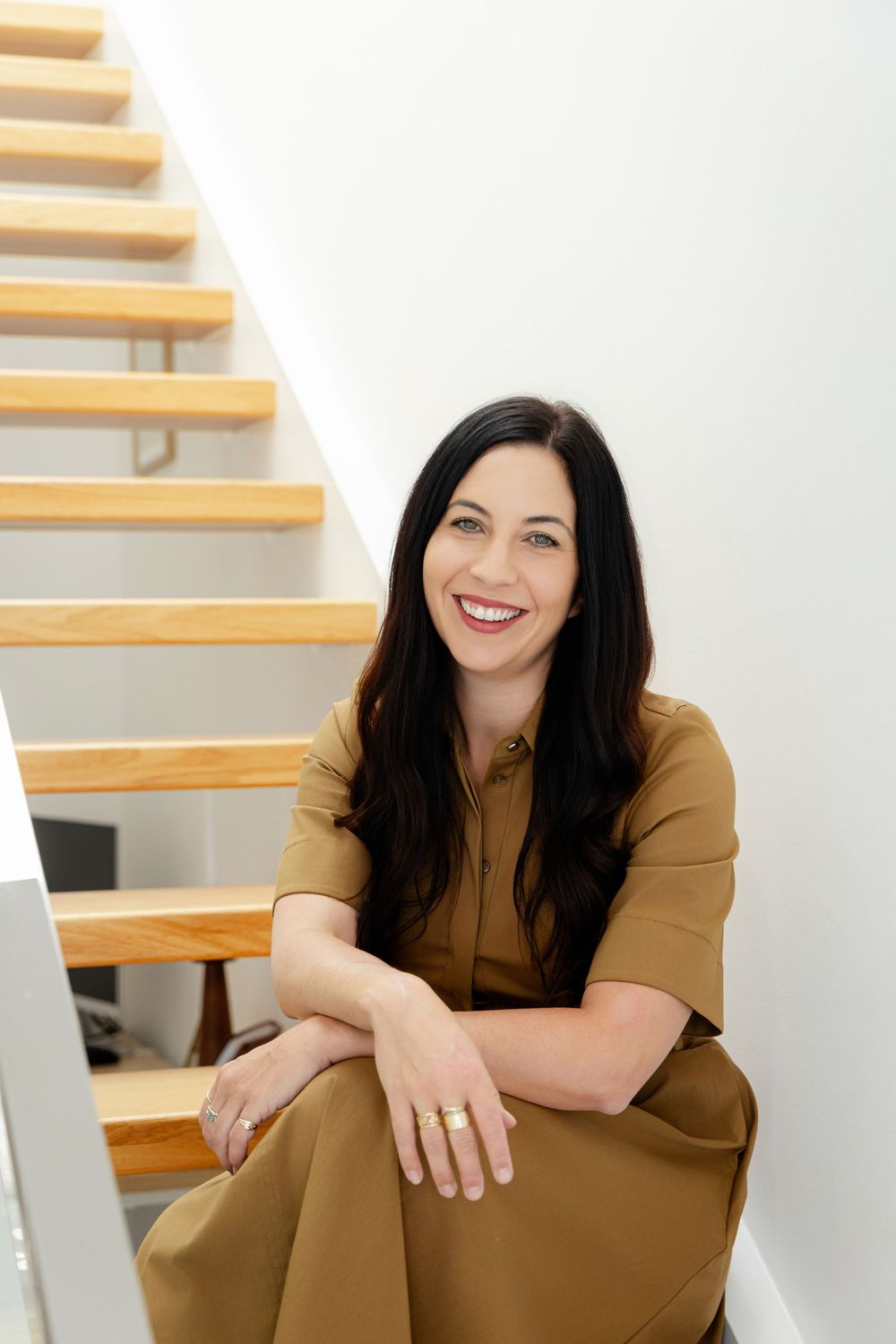 A woman sitting on a staircase in a branding photography session