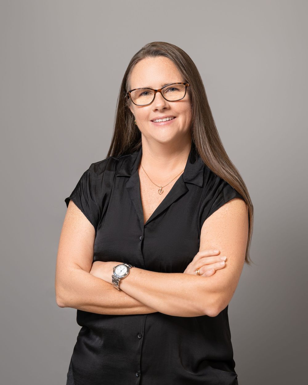 Professional studio portrait of someone in a black button-up shirt against a gray background with confident poses.