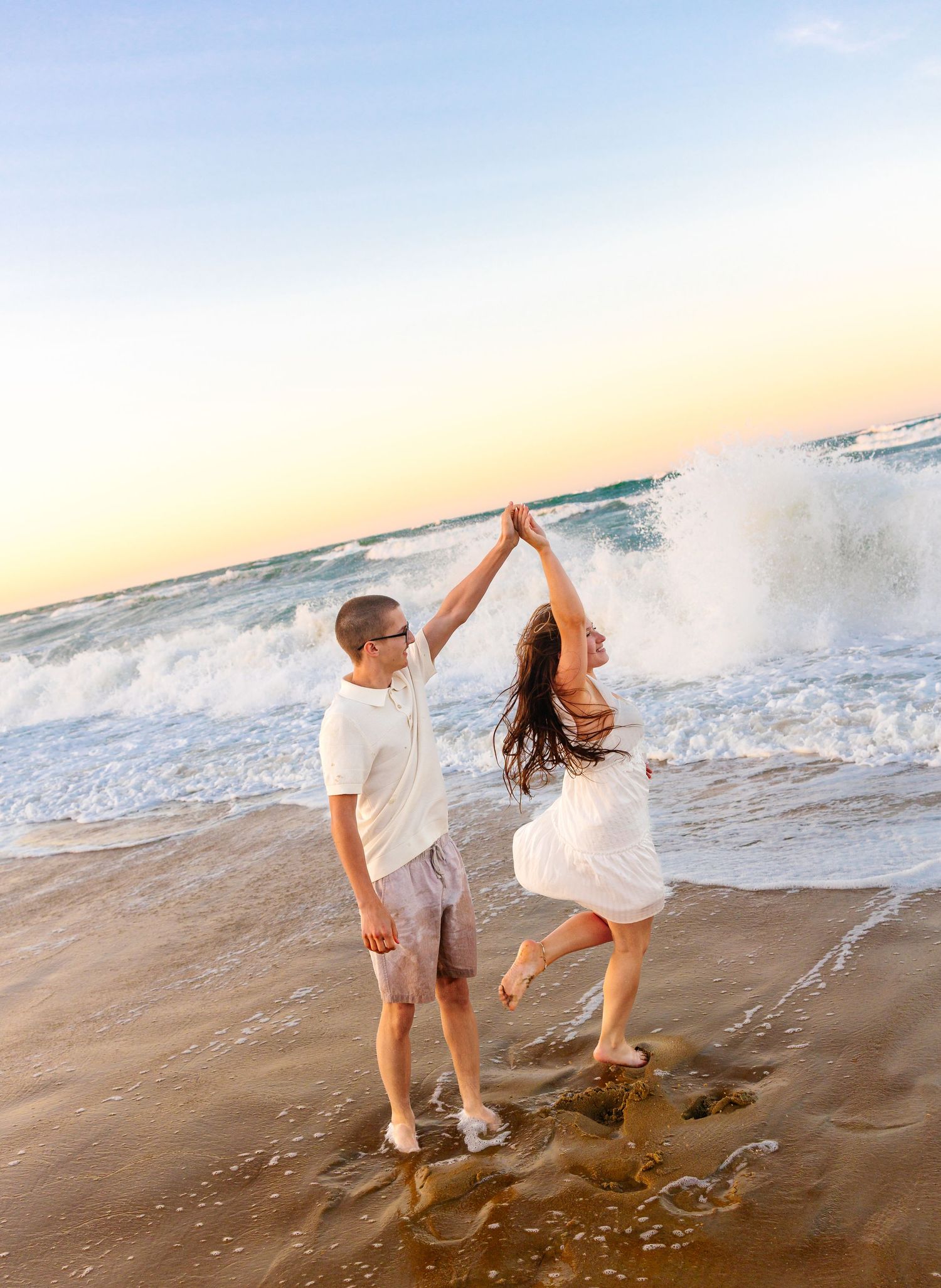 Romantic wedding couple embracing in blue suit and lace dress with wind-swept hair.