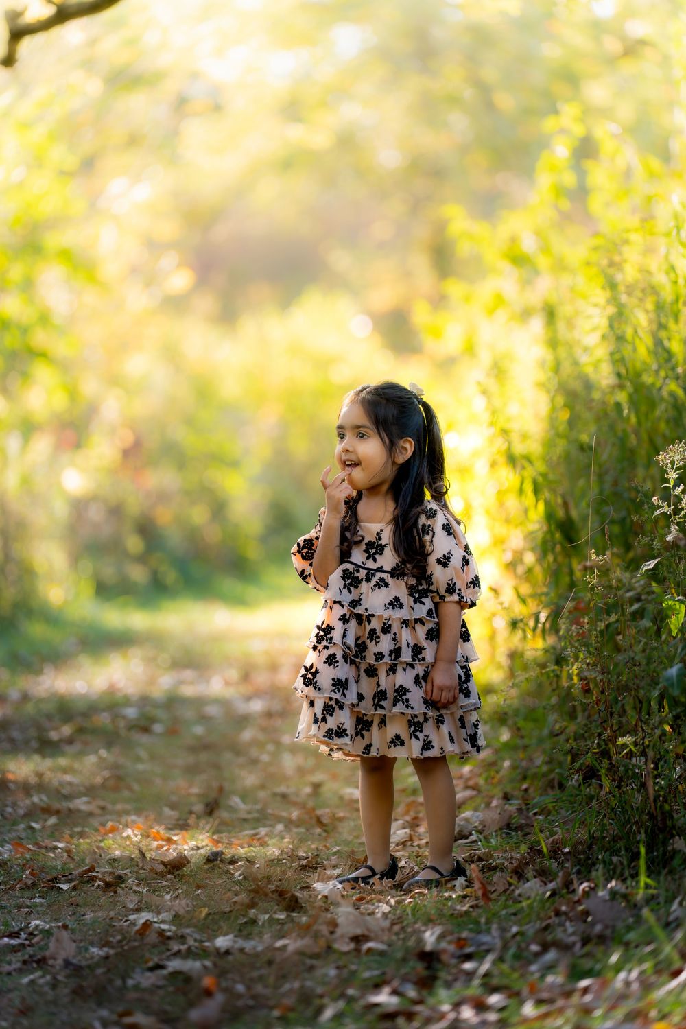 Playful poses captured in a nature setting with golden sunlight filtering through trees.