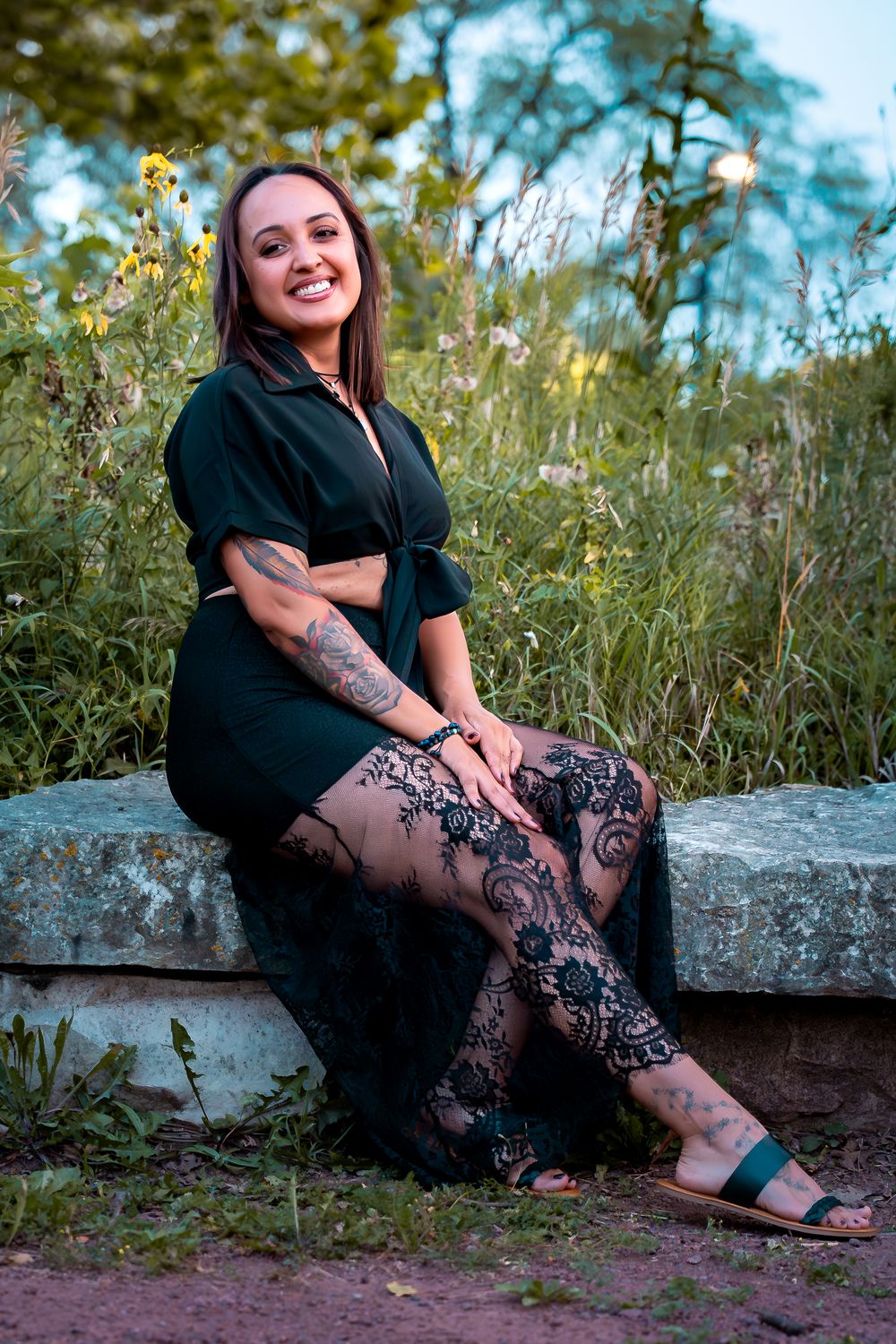 Casual outdoor portraits taken on stone steps surrounded by summer wildflowers.
