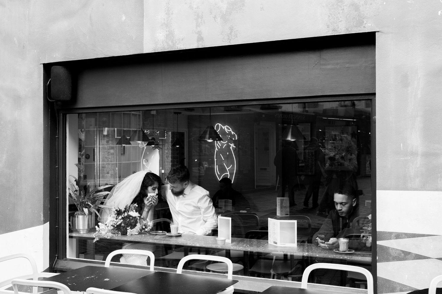A black and white panoramic view of a storefront with large windows and signage displays.