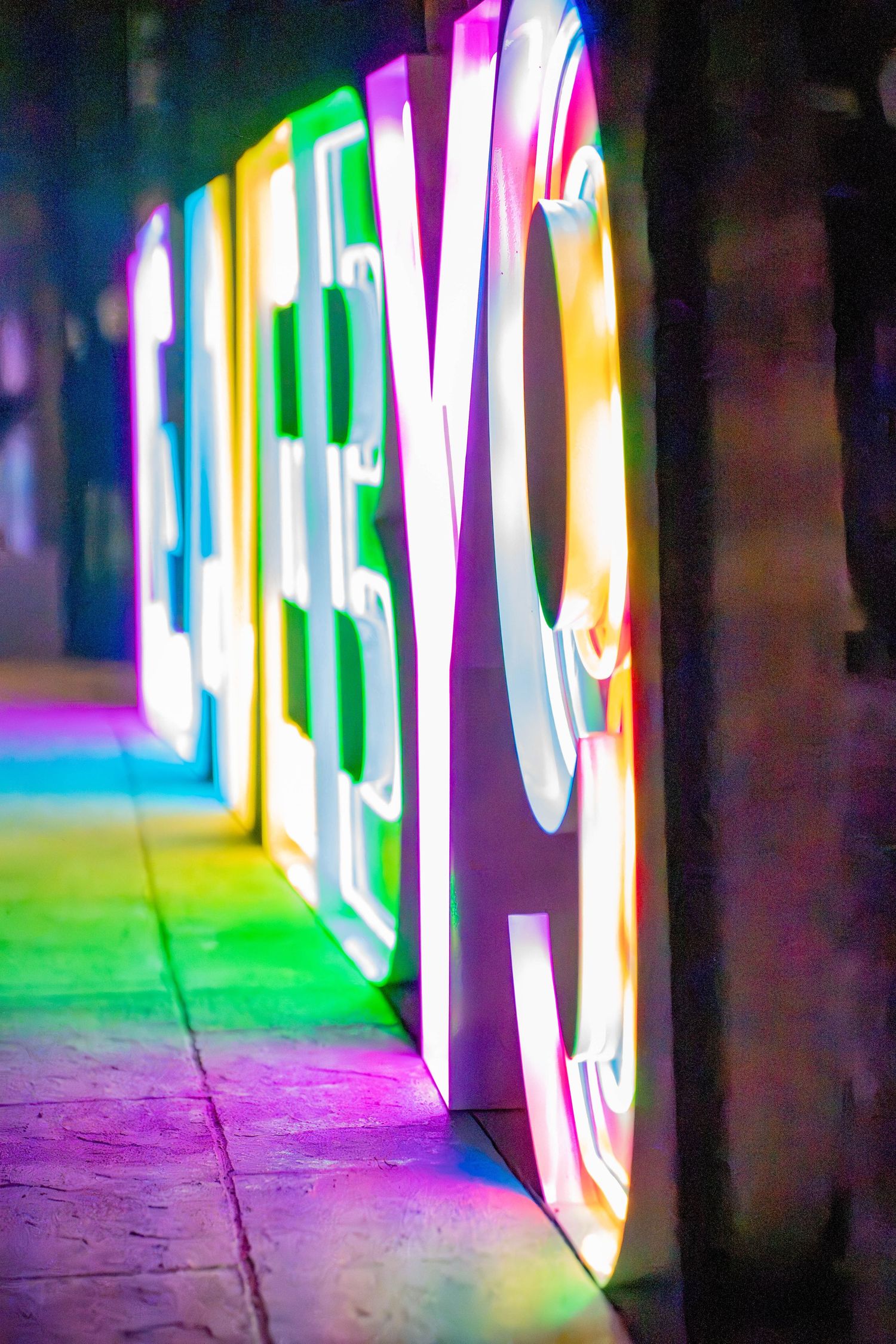New Hampshire photo of Colorful neon text signs glowing in purple and green hues.