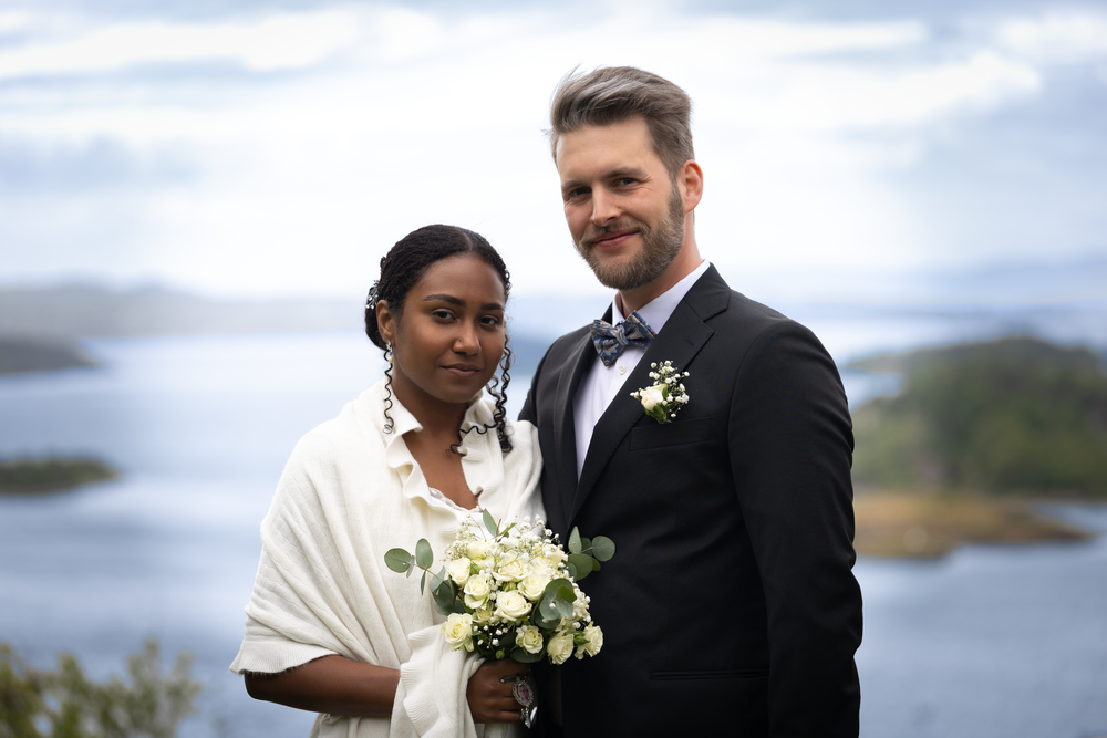 Brudepar poserer ved fjorden, naturlig bryllupsfotografering av Prospectxmedia. Bryllupsfotograf tilgjengelig i hele Norge.