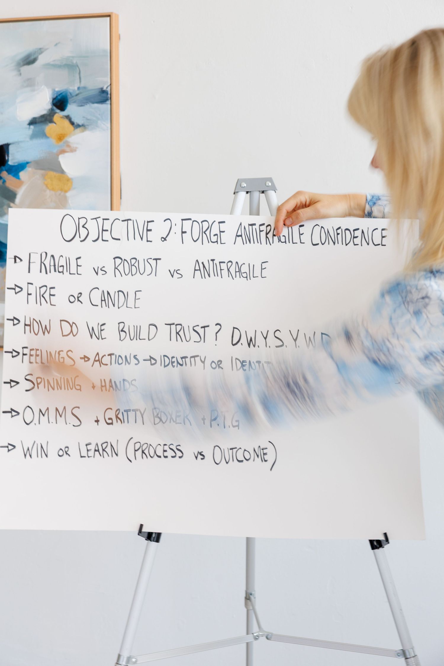 A whiteboard displays handwritten text about objectives and trust building, with a person standing beside it.