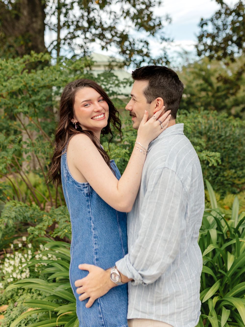 Tender embrace captured in garden setting with green foliage background.
