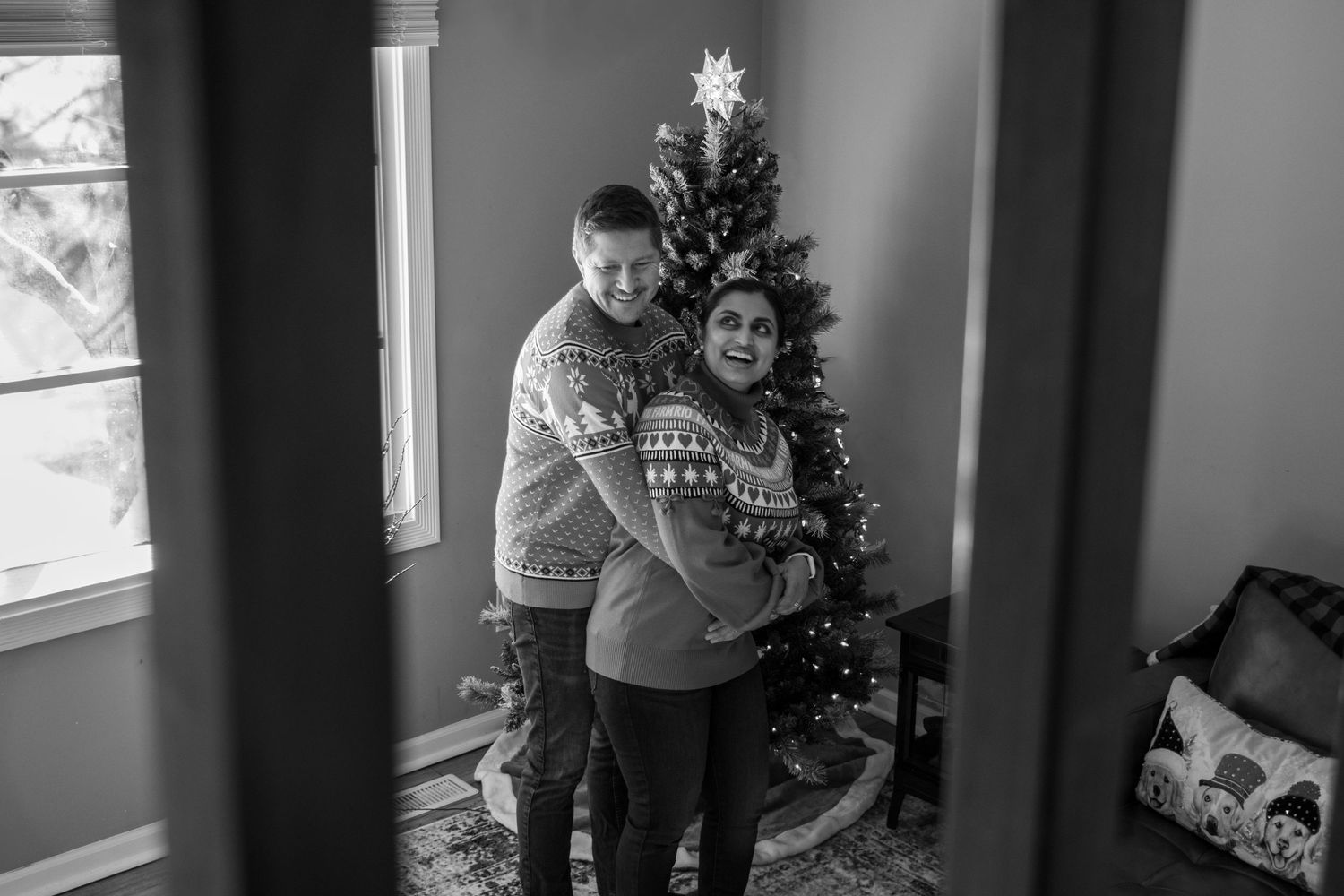 At-home holiday Christmas session featuring family decorating the Christmas tree with dog, warm indoor lifestyle photography, and festive me