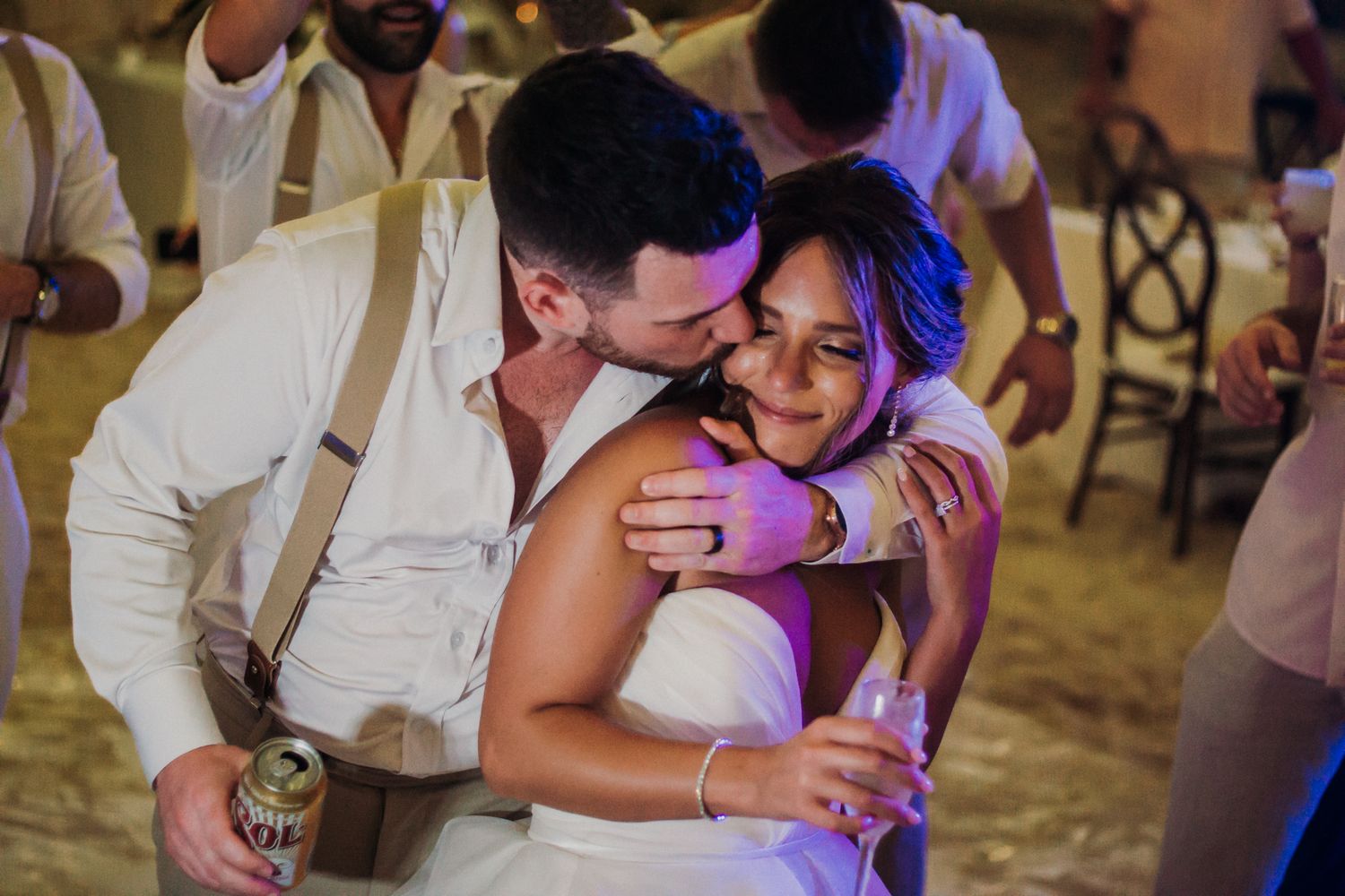 A couple shares a romantic dance moment at a wedding reception under colorful lighting.  El Dorado Royale Wedding Photographer