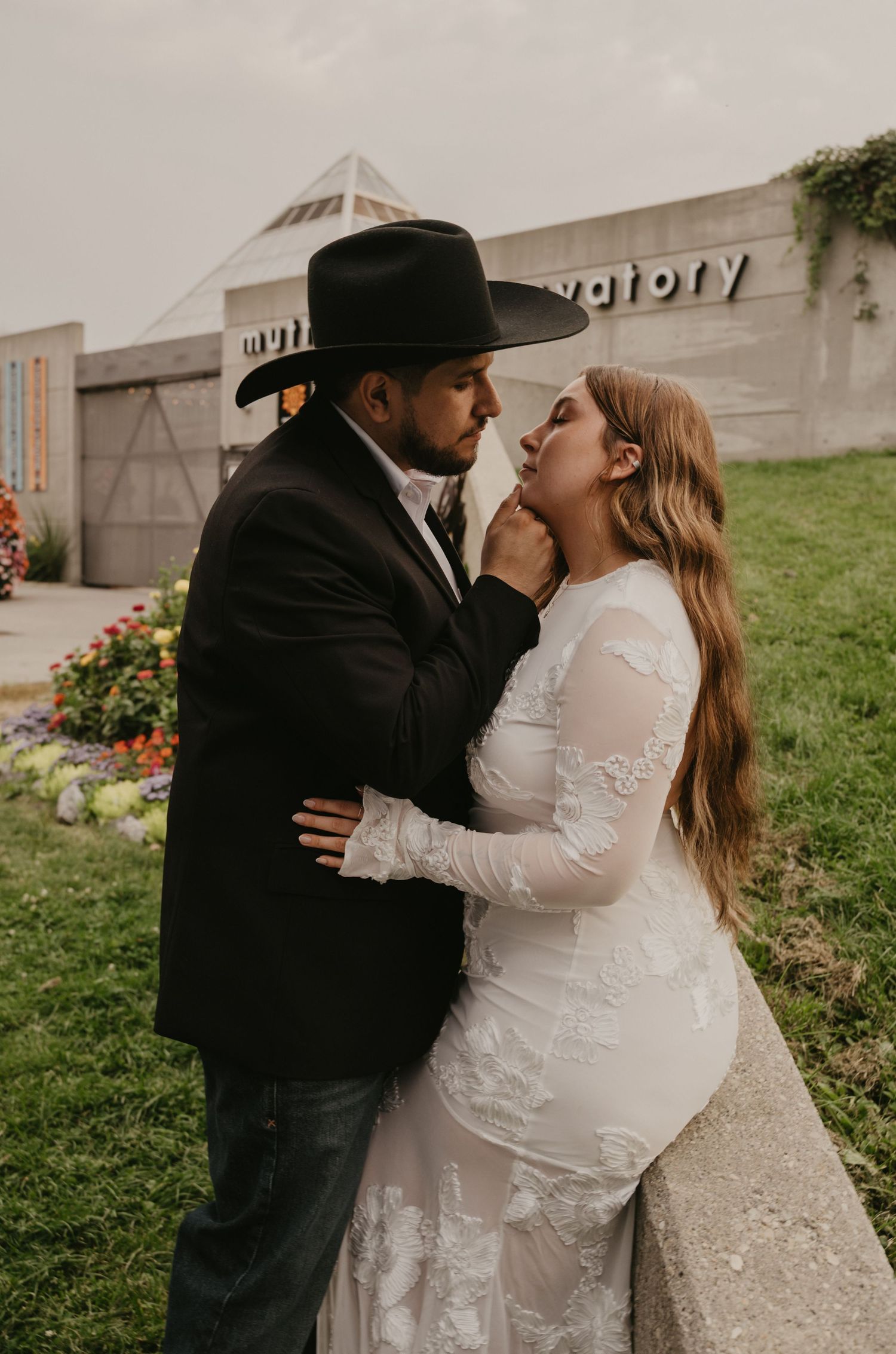 A romantic wedding couple shares tender kisses in a series of intimate outdoor portraits against a grassy backdrop.