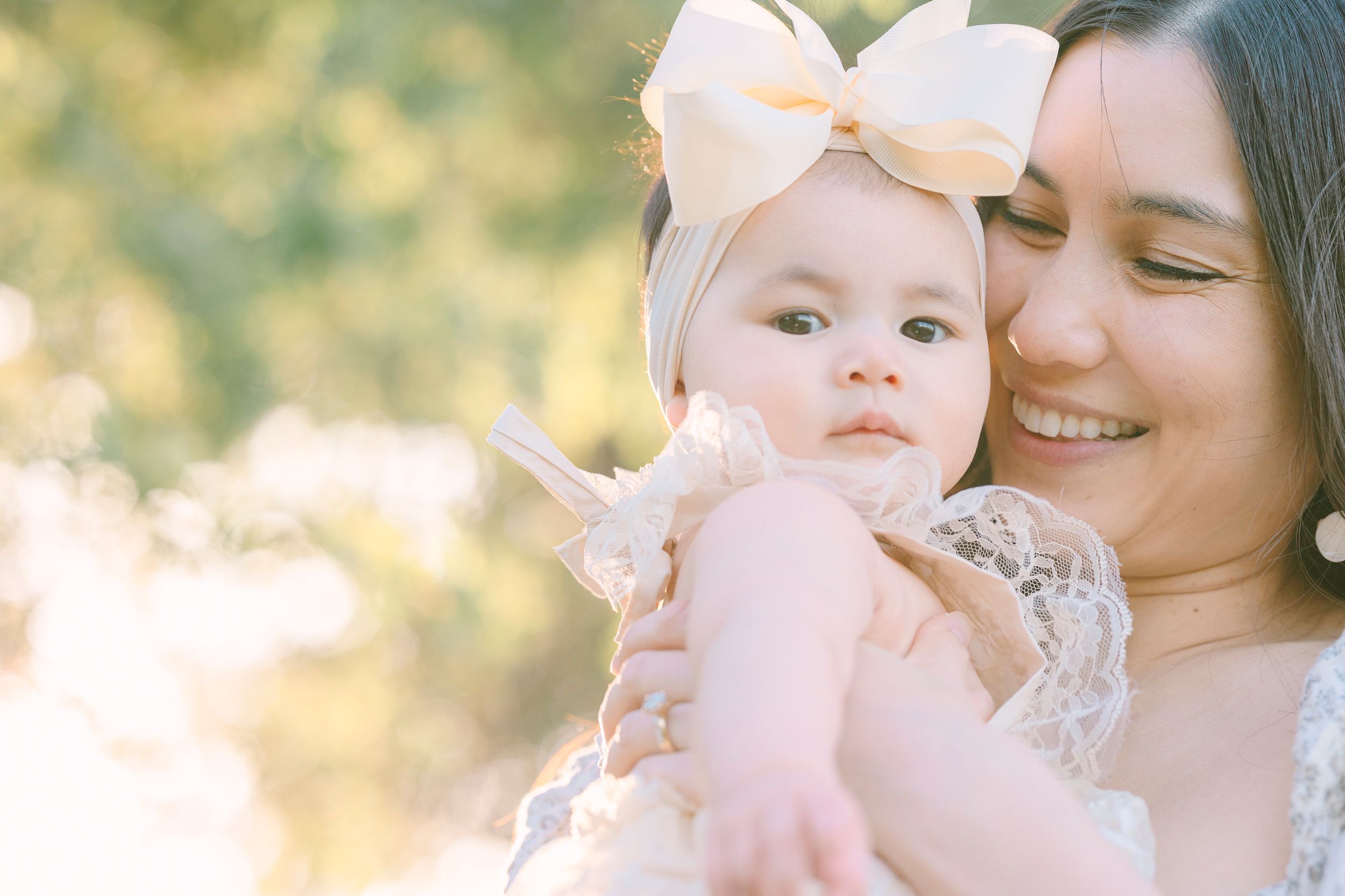 Mother and baby sharing tender moments in a sunlit outdoor setting.