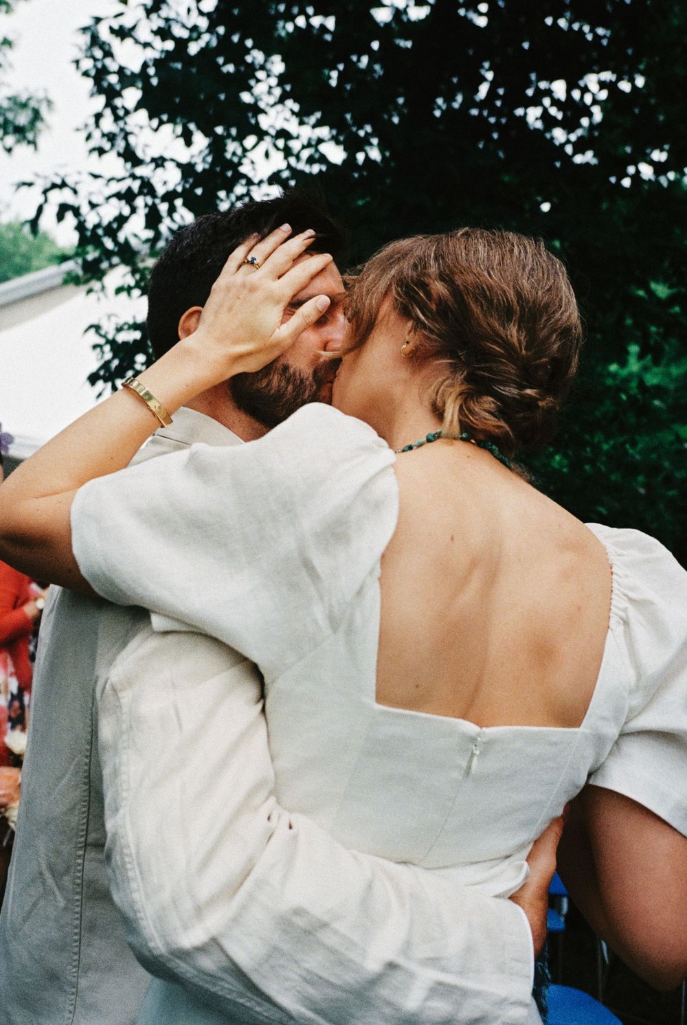 The bride gently touches the face of groom right after their wedding ceremony under the trees in the backyard of their Rhinebeck, NY home.