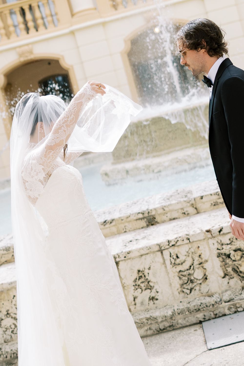 A bride and groom share an intimate moment on stone steps during their wedding photoshoot.