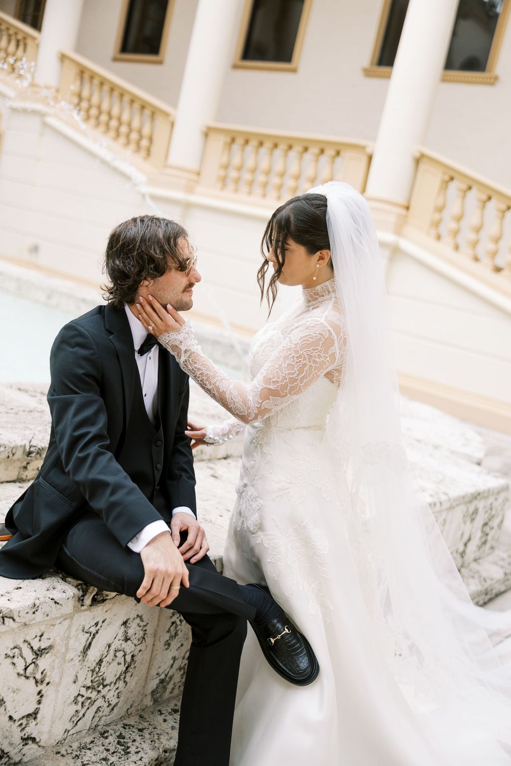 A romantic wedding photoshoot showing tender moments between a couple on ornate stone steps.