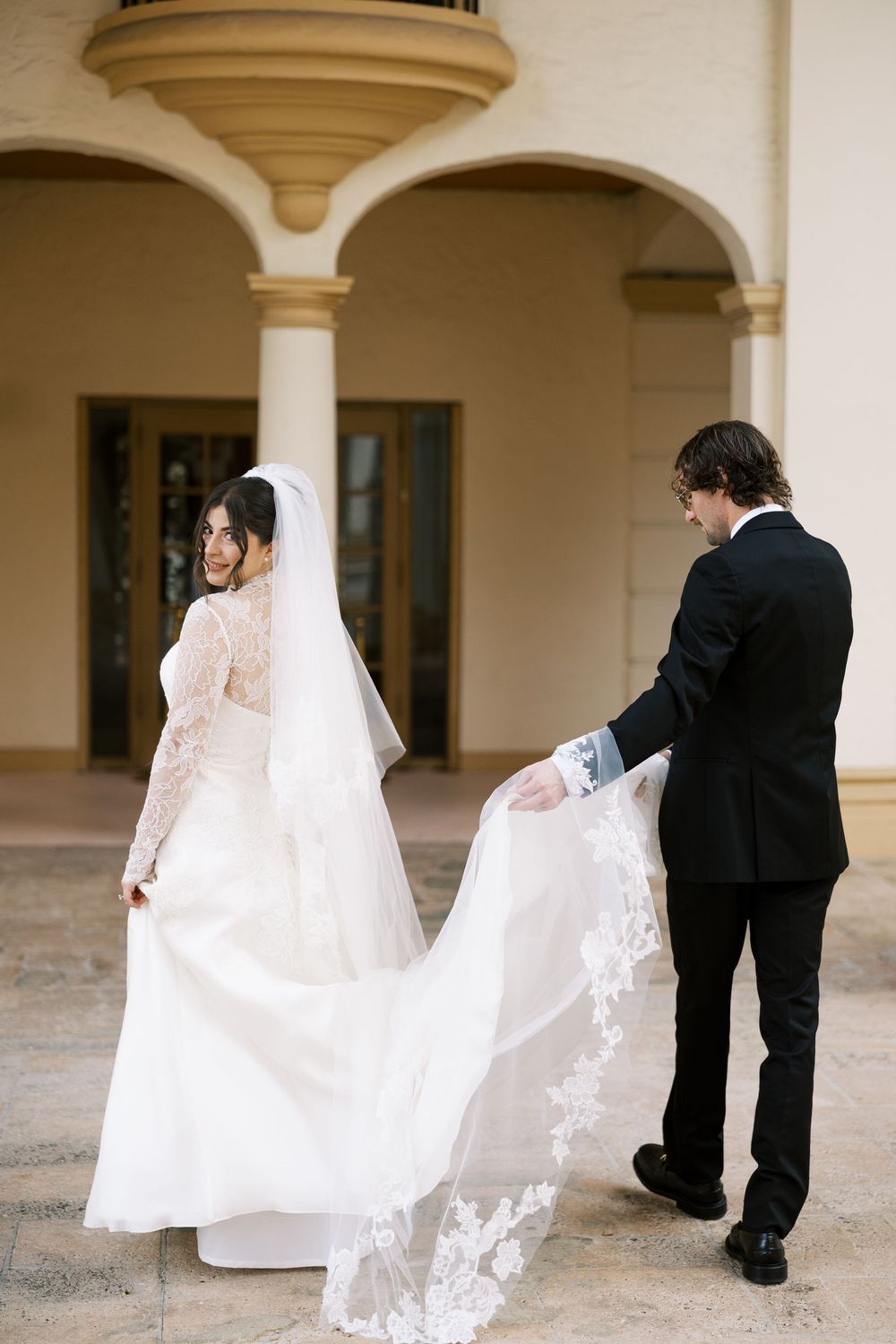Wedding sequence showing elegant dress movements and interactions under arched columns.
