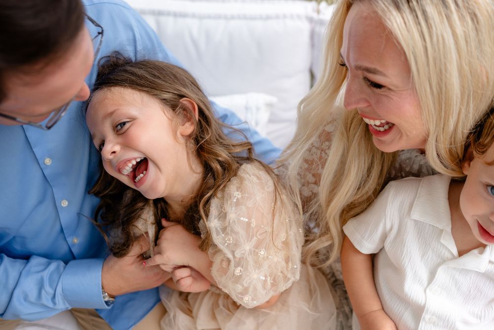 A joyful family moment captured in a series of candid black and white photographs showing laughter and embraces.