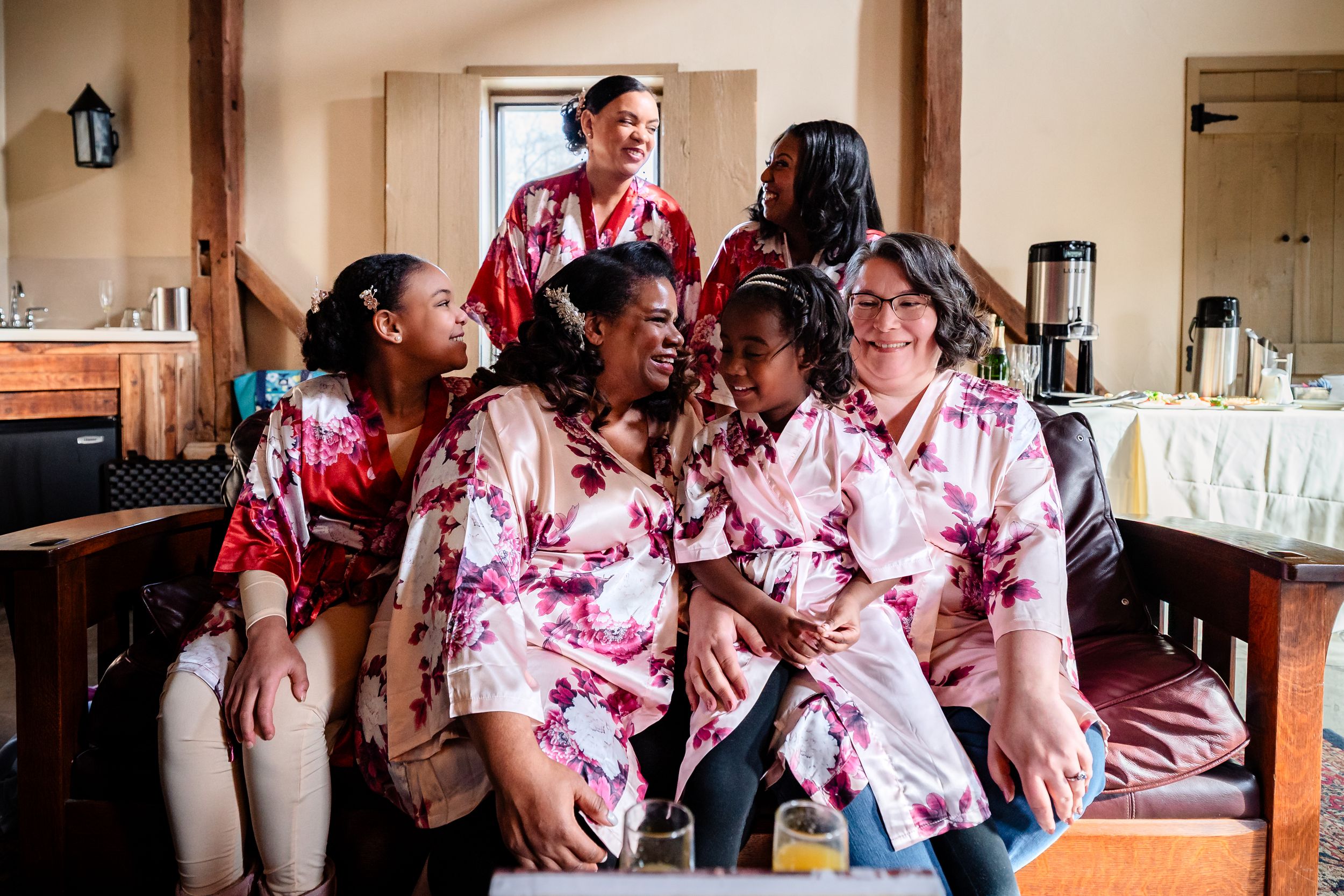 A group wearing matching red and white tie-dye outfits gathers together at an indoor event.