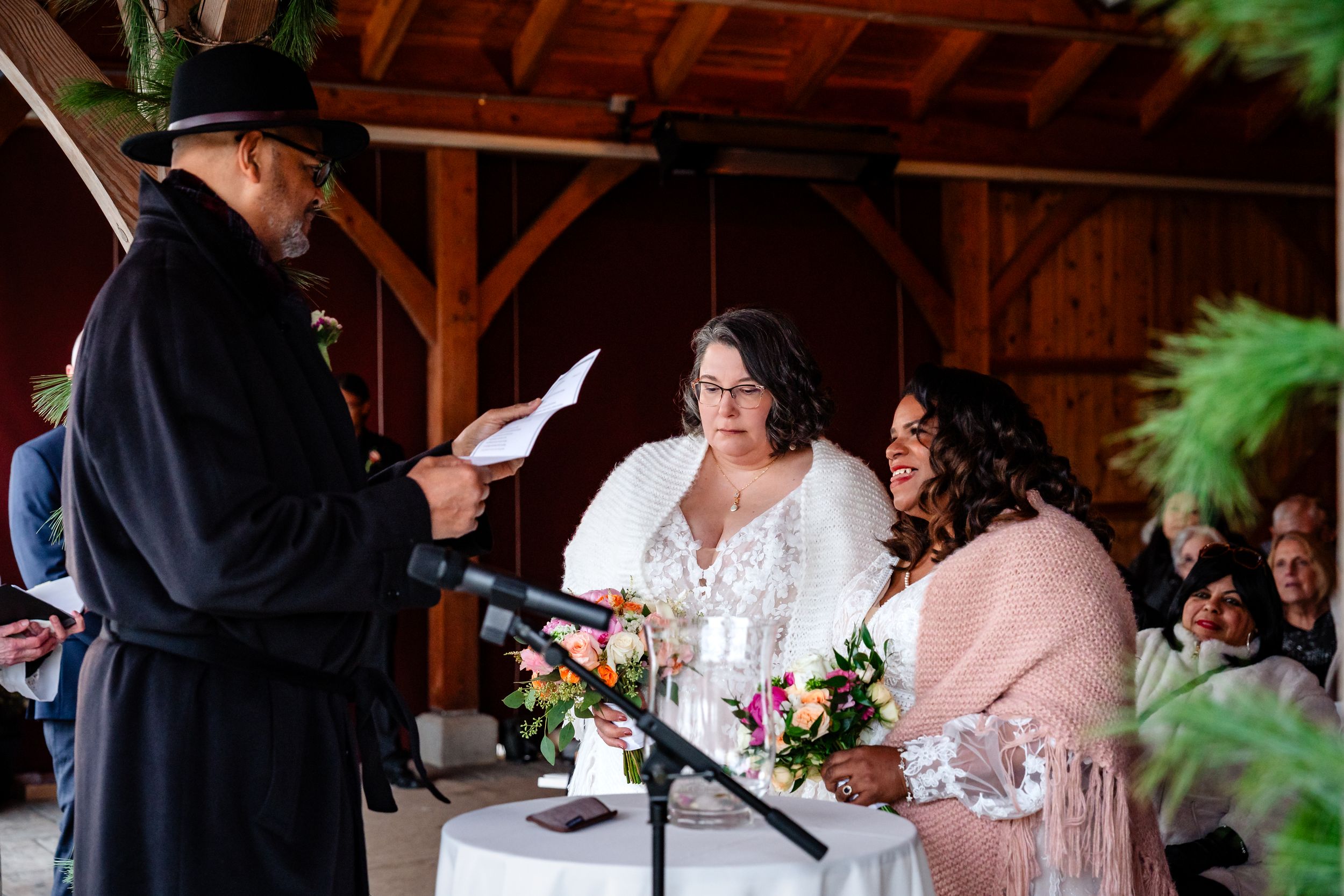 Wedding guests enjoy a lively celebration inside a rustic wooden barn reception venue.