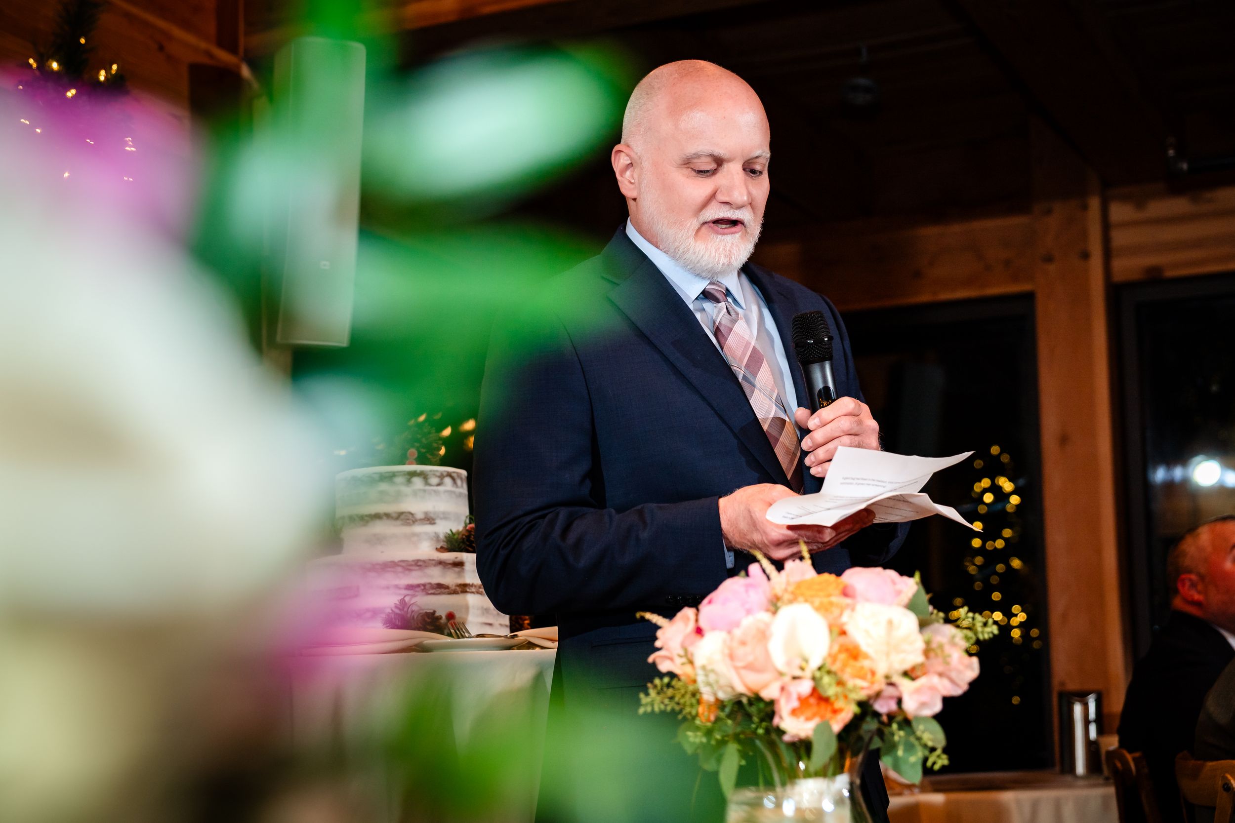 Wedding reception speeches and toasts being given in an elegantly decorated venue with soft lighting.