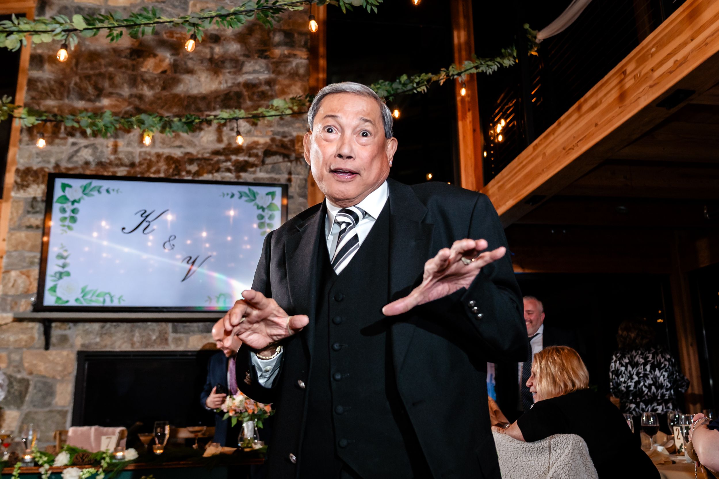 Wedding reception venue features exposed brick walls and elegant evening lighting.