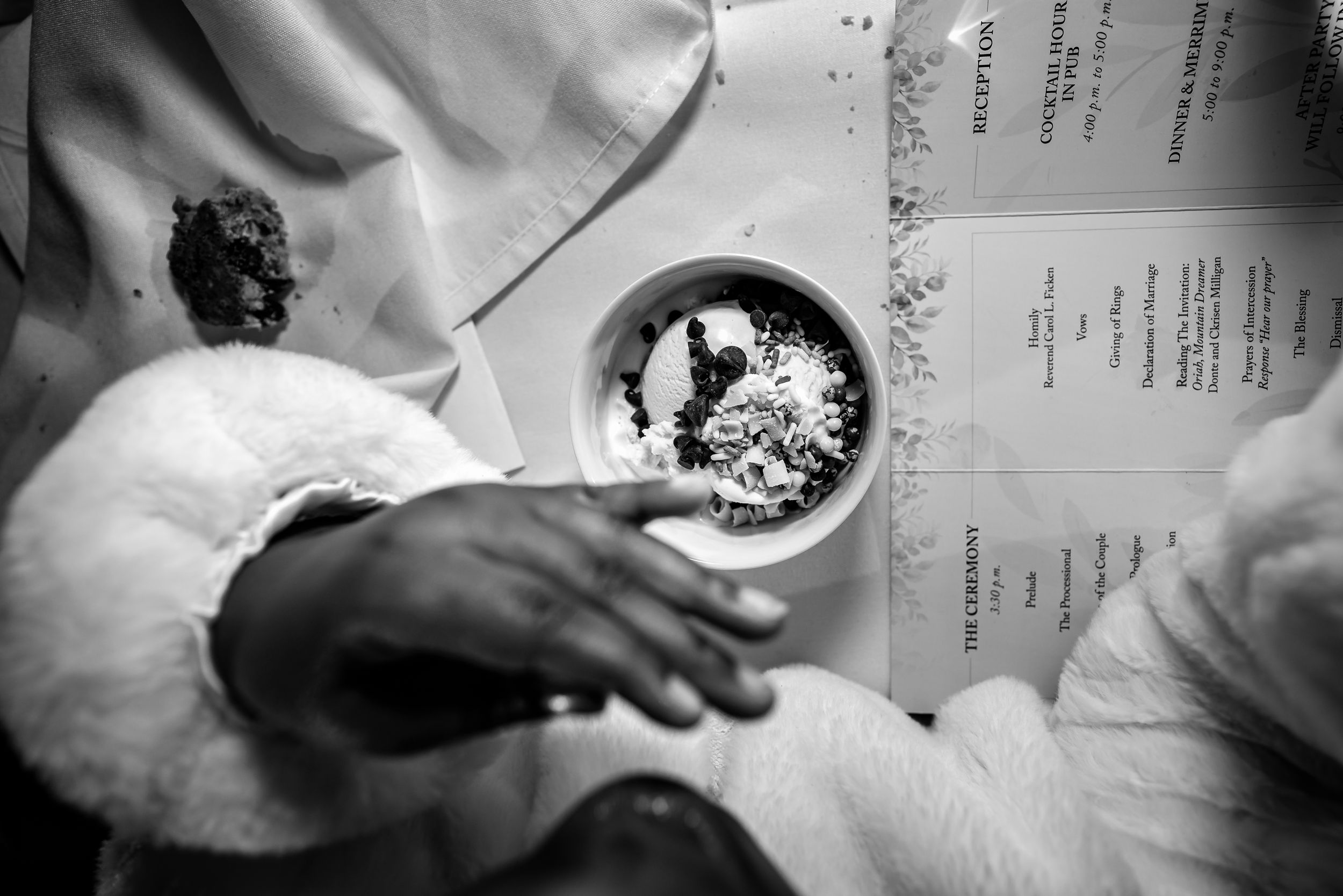 Black and white photo of hands preparing food in a commercial kitchen setting.