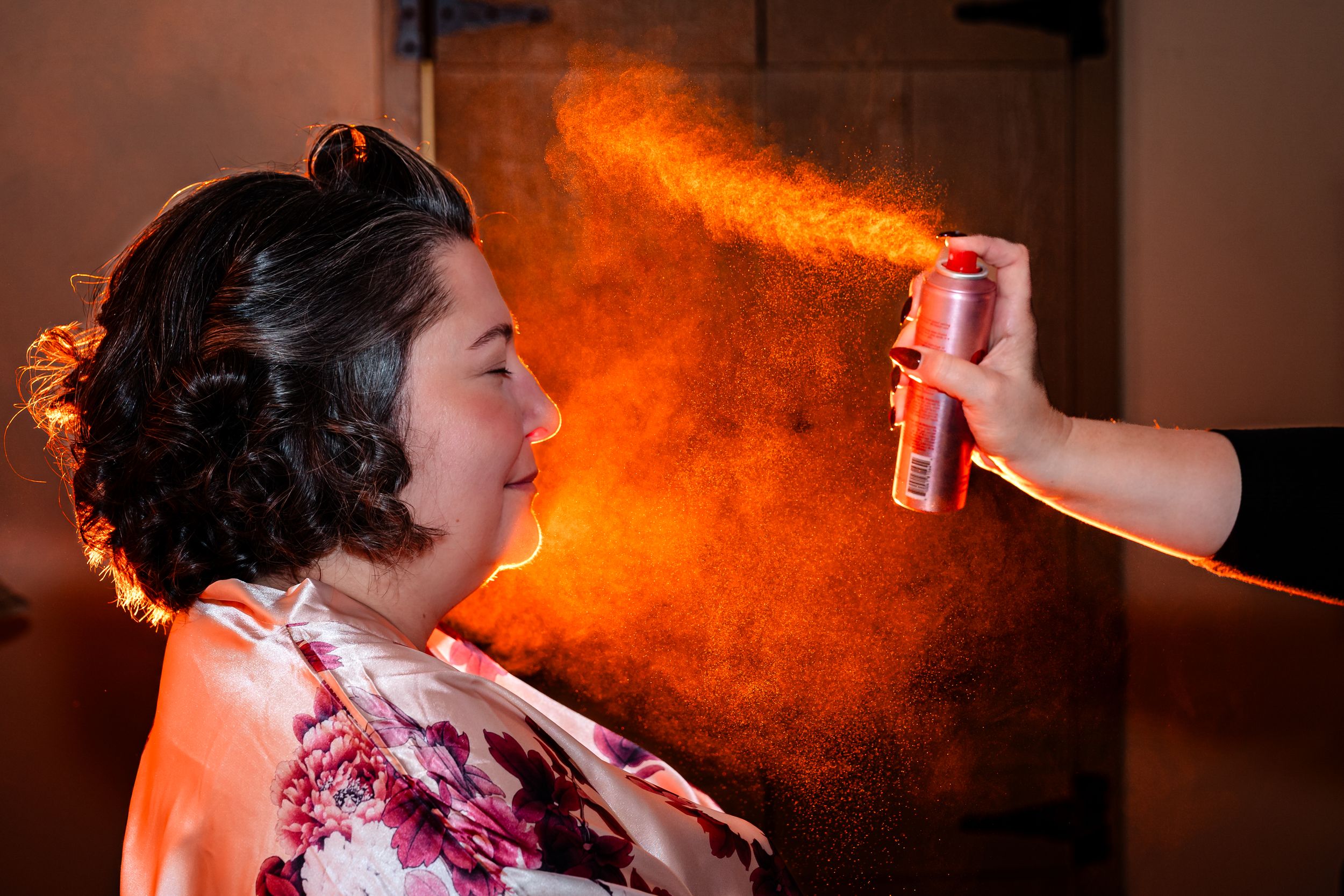 Warm orange lighting creates atmospheric glow during wedding preparation moments.