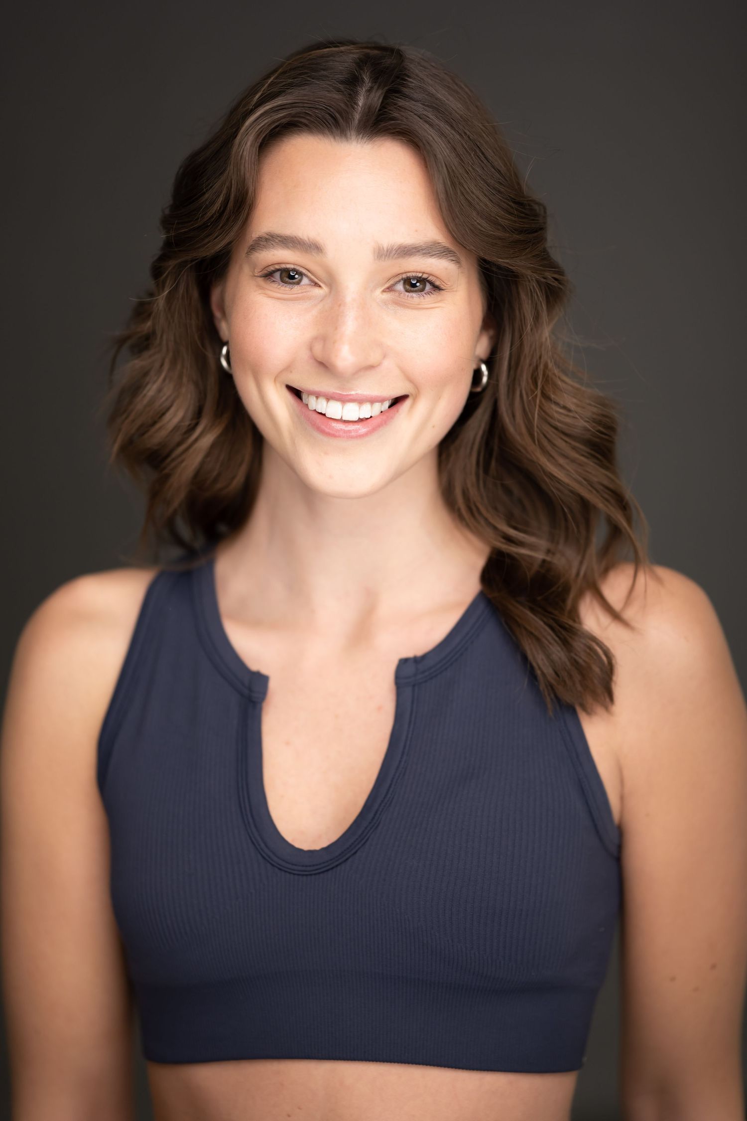 Portrait series showing person in navy athletic top against dark background.