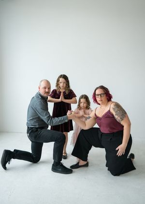 A sequence of dance poses shows four people in black and burgundy outfits performing coordinated movements against a white backdrop.