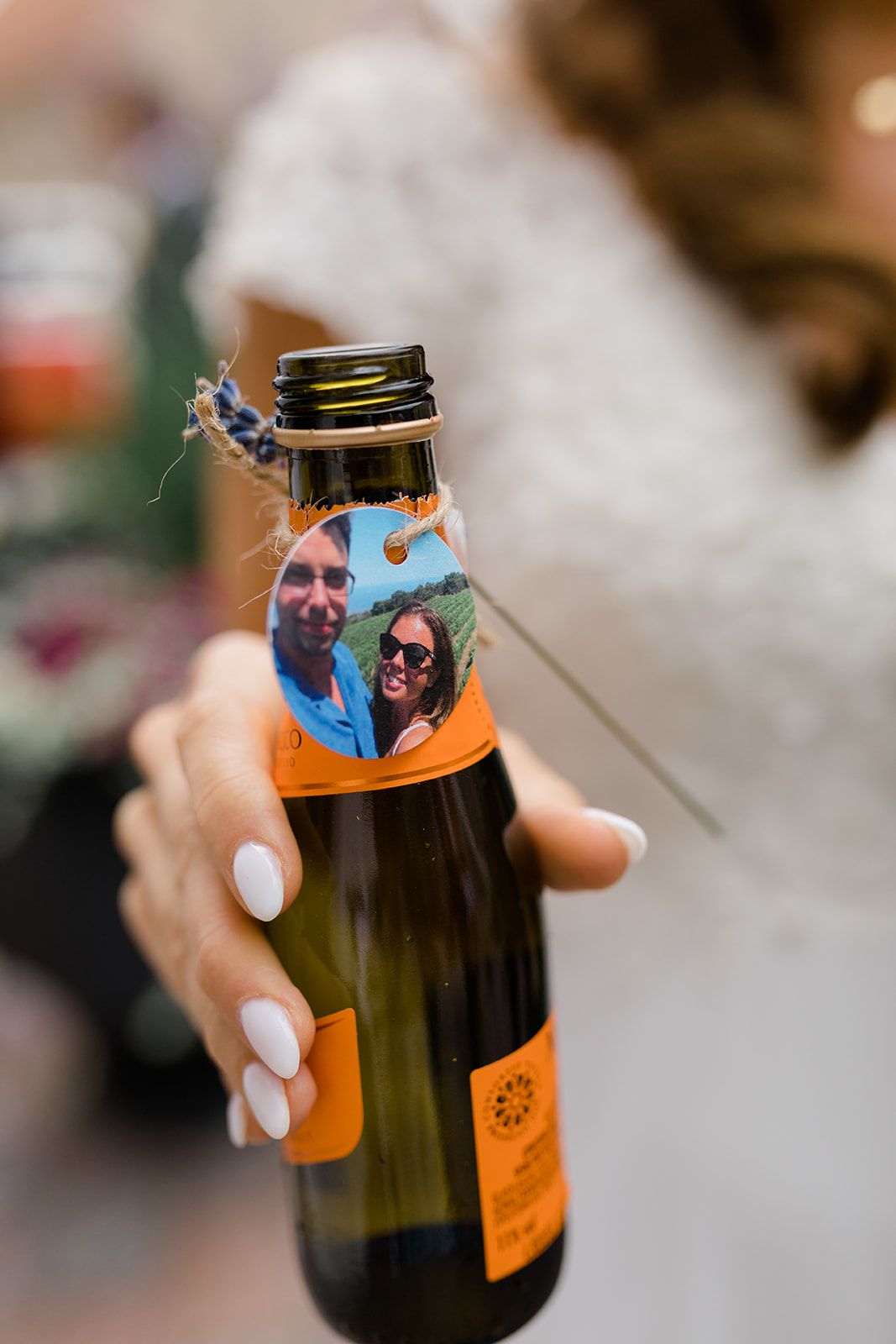 A hand holding a dark glass bottle with an orange label being opened in a sequence of motion blur shots.