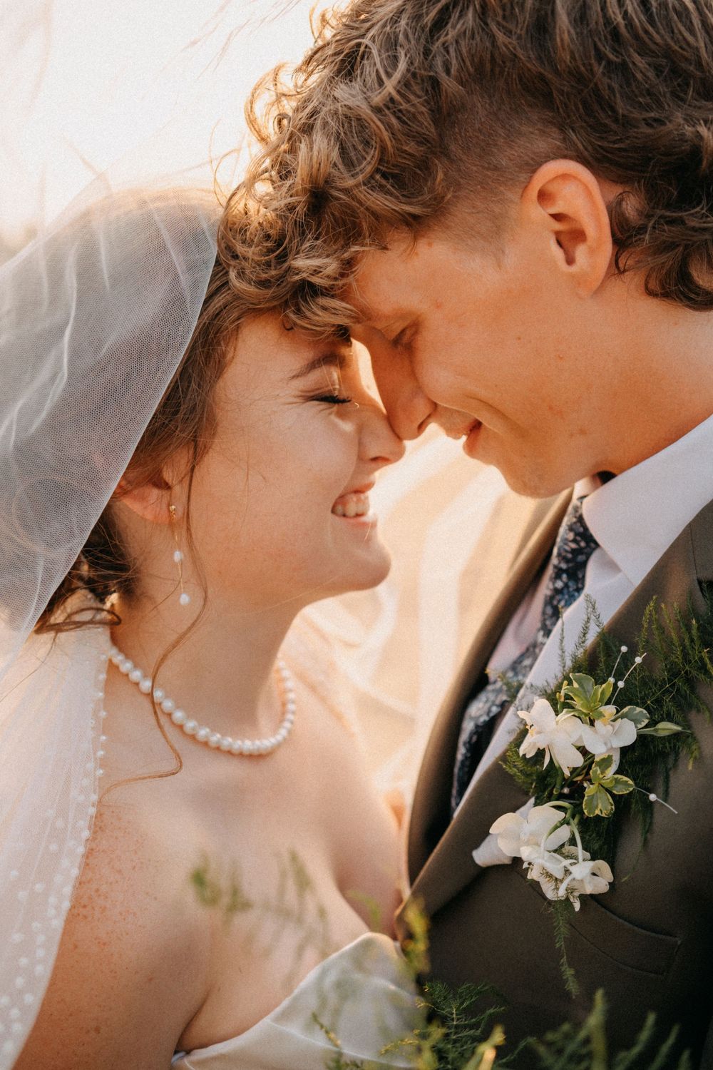 Romantic close-up wedding portraits showing tender moments between newlyweds in warm sunlight.