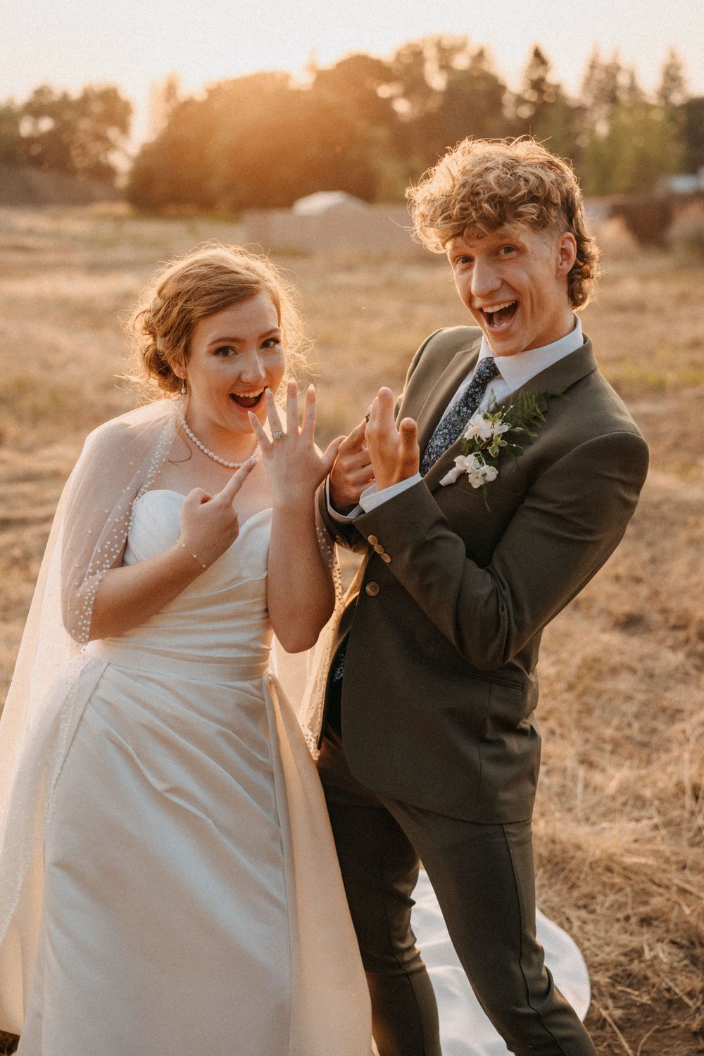 Candid wedding photos capture joyful laughter between a couple during sunset portraits in a rustic field.