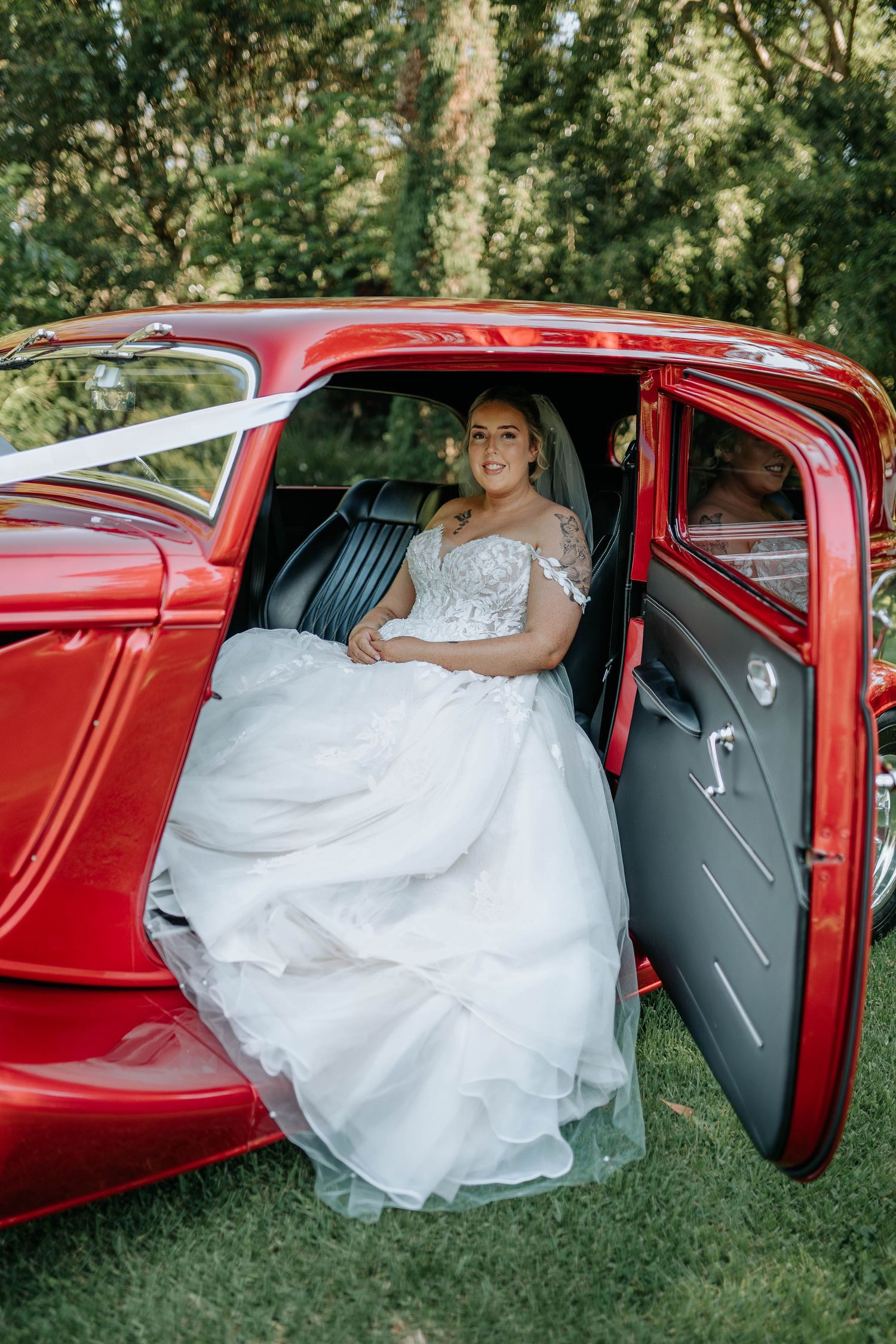 A sequence of photos showing someone in a white wedding dress getting into a classic red vintage car.