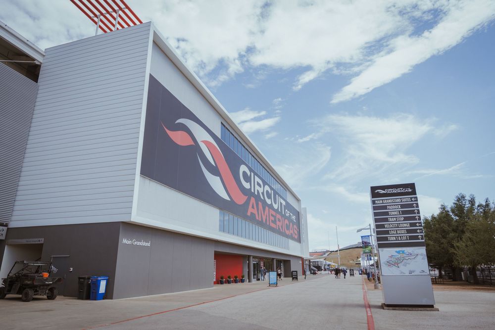 Exterior view of a large commercial building with white walls under blue sky.