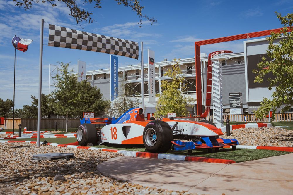 Wide panoramic view of an outdoor go-kart racing facility with red track markings.