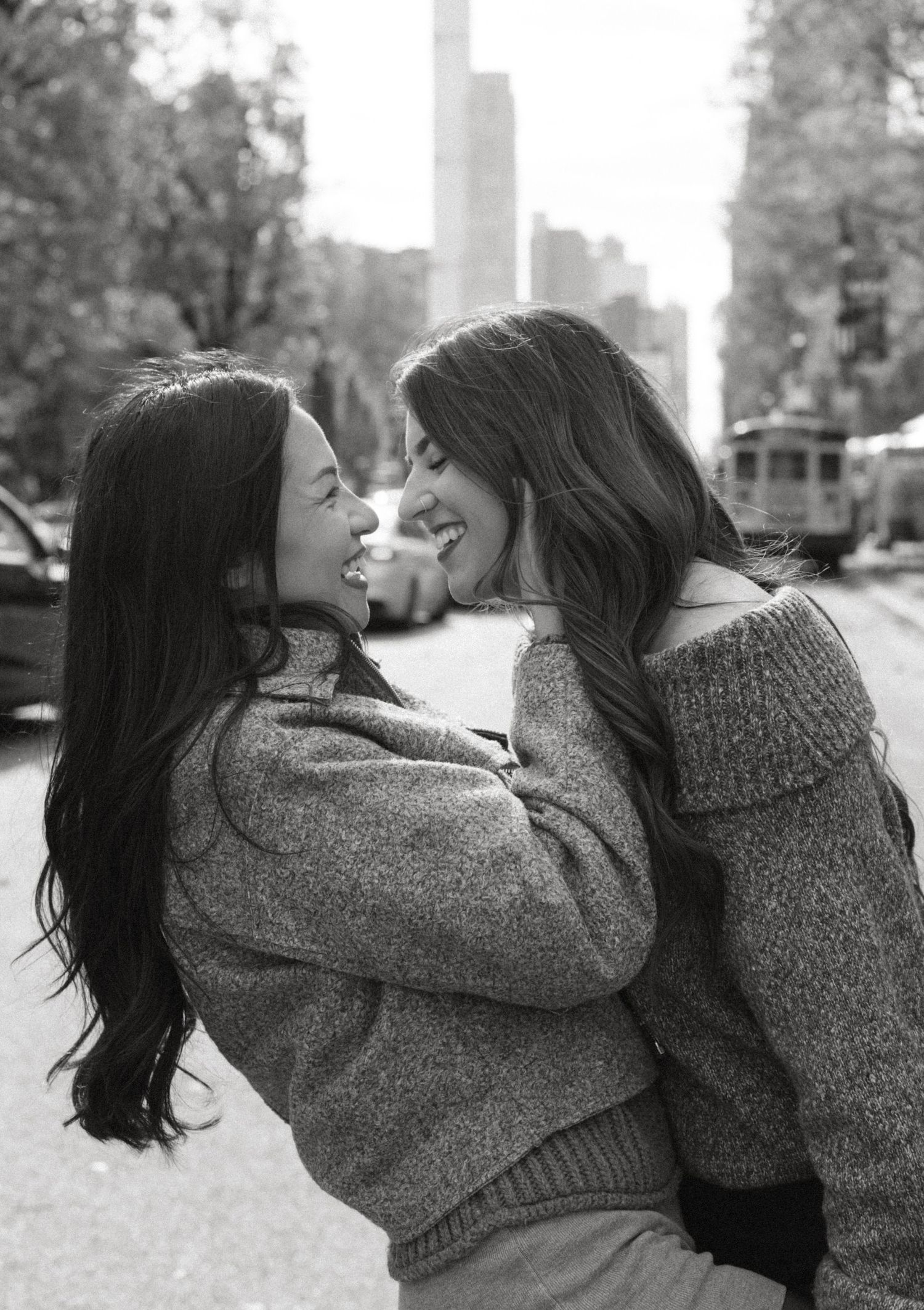 A black and white photo series showing two people in knit sweaters embracing outdoors.