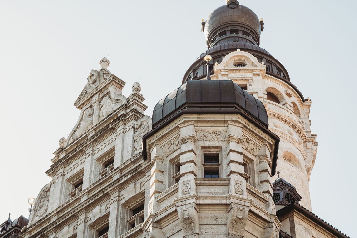 Ornate baroque architecture with domed towers and detailed stone carvings against blue sky.
