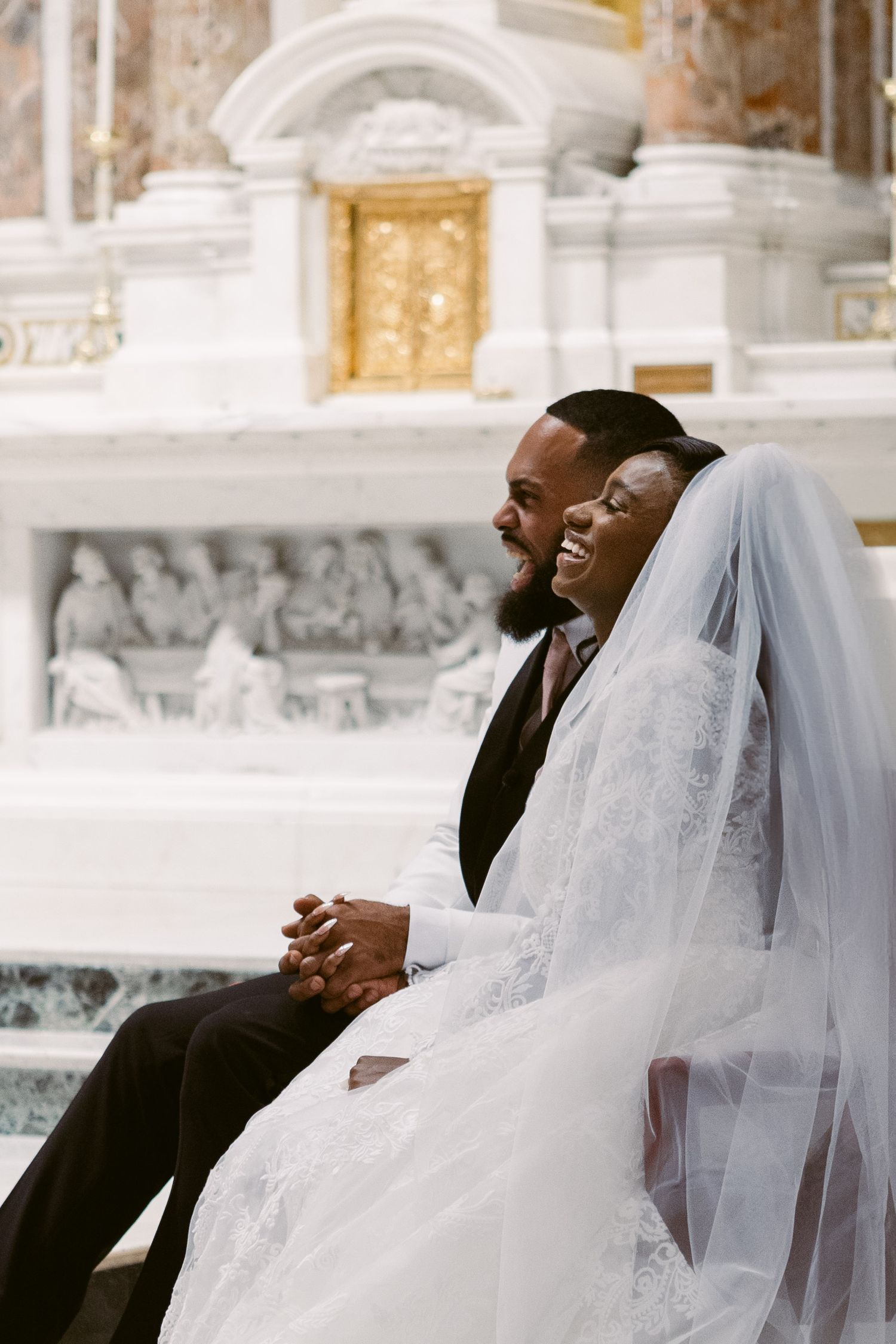 Bride and groom laughing at their priest's homily